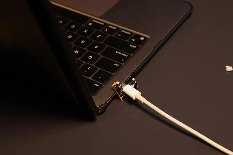 A charging cable being connected to a laptop